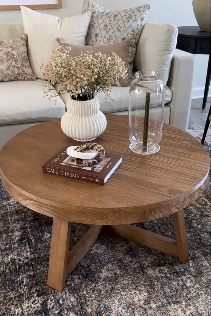 a coffee table with flowers in a vase on top