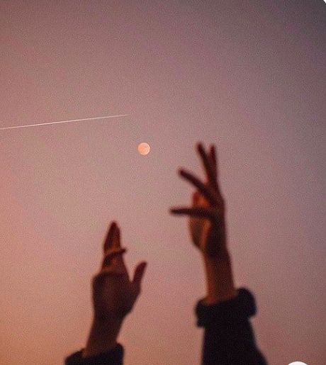 two people reaching up to the sky with their hands