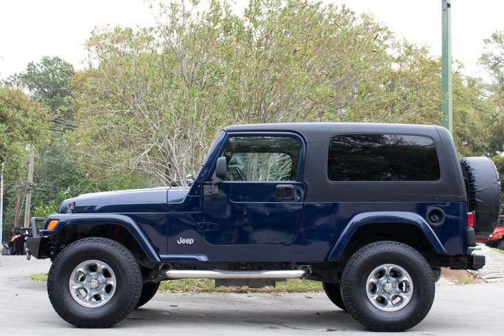 a blue jeep is parked in a parking lot