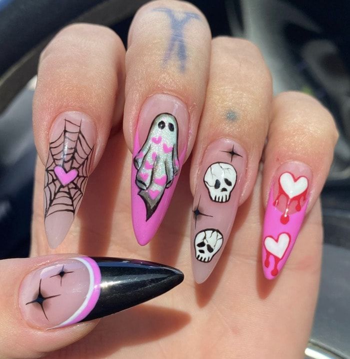 a woman's hand with halloween nail art on it