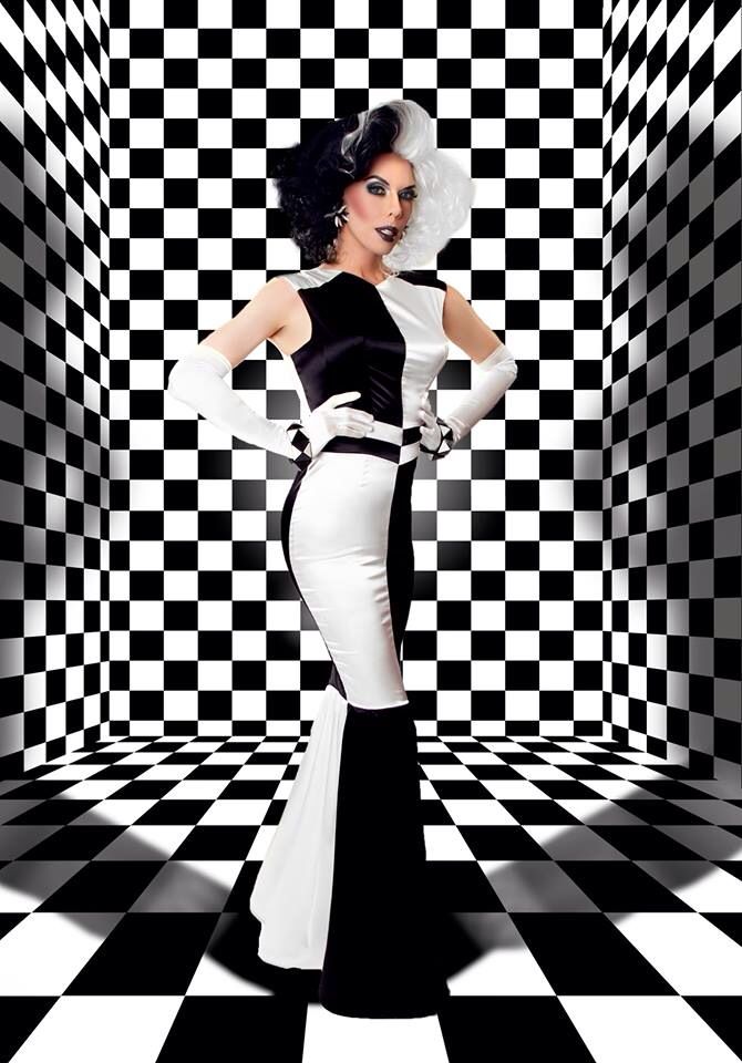 a woman in a black and white dress is standing on a checkered floor with her arms behind her back