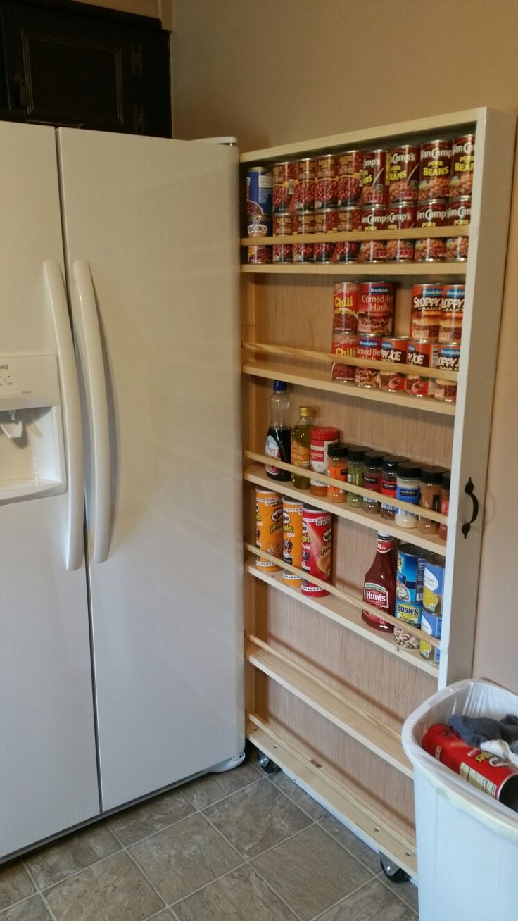 a refrigerator and freezer combo in a kitchen with the door open to reveal pantry items