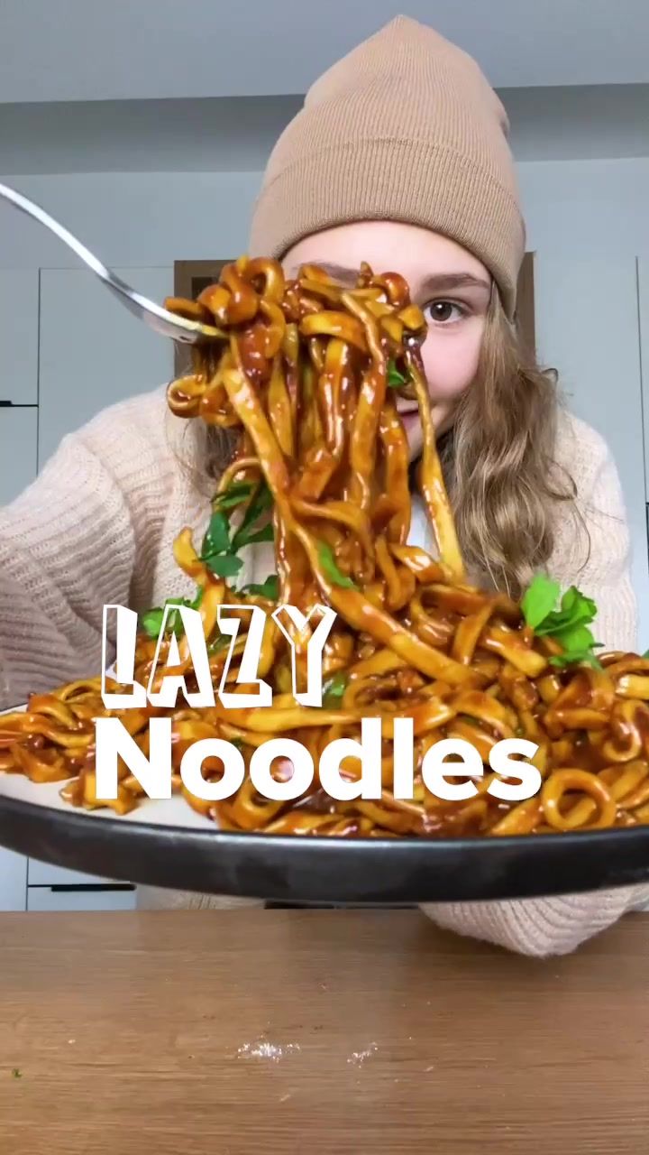 a woman is holding a plate full of food with the words lazy noodles on it