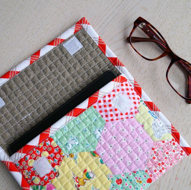 a pair of glasses sitting on top of a table next to a patchwork wallet