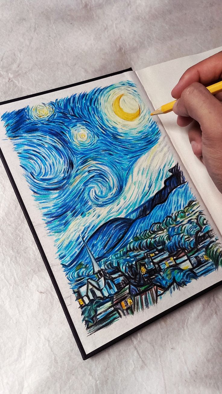 a person is drawing with colored pencils on a piece of paper that looks like the starry night