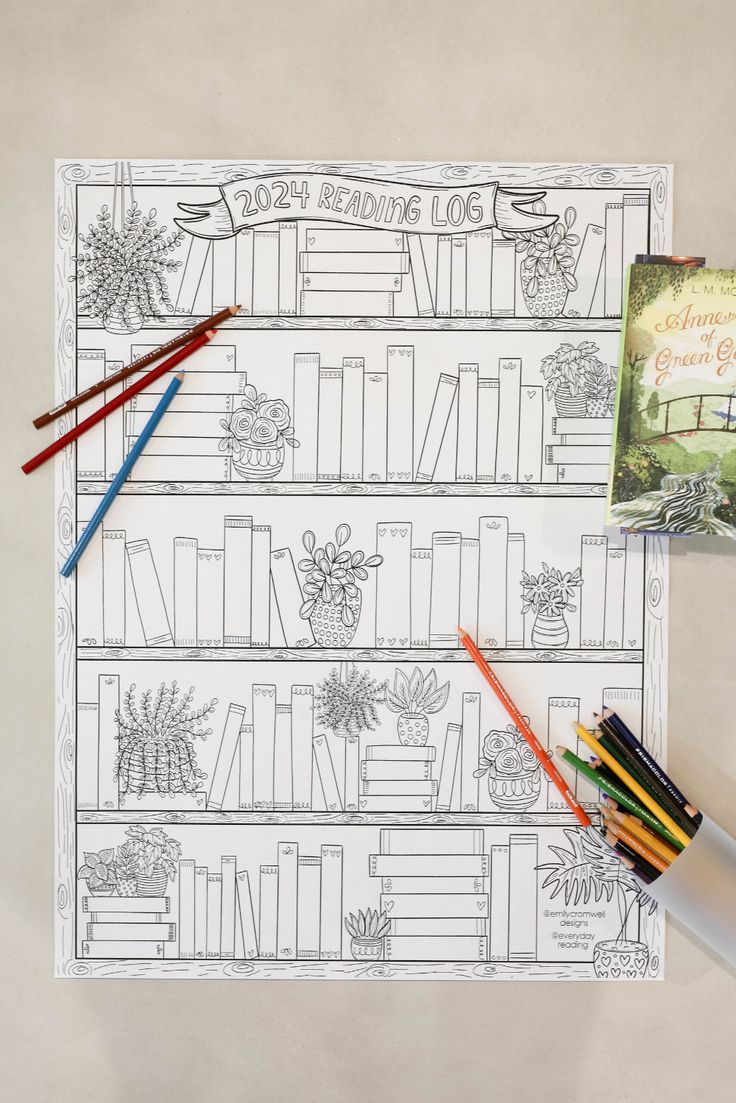 the coloring book is next to some colored pencils