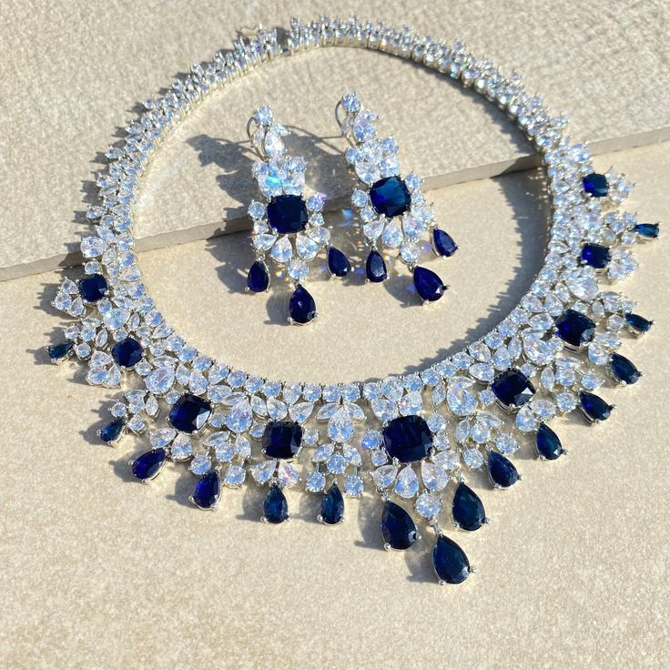 Sapphire STATEMENT Necklace LUXURY set this PREMIUM QUALITY necklace features semi precious royal blue stones with CZ diamonds. Ideal to pair with your bridal wedding white gown or any navy blue gown / prom gown. Also a perfect gift for her. *𝐏𝐑𝐎𝐃𝐔𝐂𝐓 𝐃𝐄𝐓𝐀𝐈𝐋* * 𝐌𝐚𝐭𝐞𝐫𝐢𝐚𝐥: Brass * 𝐏𝐥𝐚𝐭𝐢𝐧𝐠: White Rhodium Plated * 𝐒𝐭𝐨𝐧𝐞: AAA-quality CZ Diamond & Sapphire. *𝐃𝐈𝐌𝐄𝐍𝐒𝐈𝐎𝐍𝐒* *𝐍𝐞𝐜𝐤𝐥𝐚𝐜𝐞* * 𝐖𝐞𝐢𝐠𝐡𝐭: 140 gm * 𝐃𝐫𝐨𝐩 𝐋𝐞𝐧𝐠𝐭𝐡: 7.5 Inches *𝐄𝐚𝐫𝐫𝐢𝐧 Navy Blue Gown, Sapphire Wedding, Cz Jewelry, Cz Diamond, Blue Diamond, Perfect Gift For Her, Blue Stone, Luxury Jewelry, Royal Blue