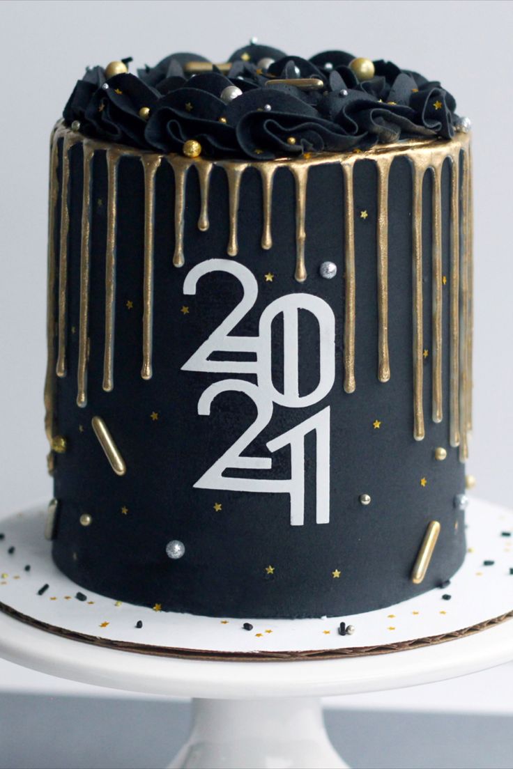 a black cake with gold sprinkles and the number twenty one on it