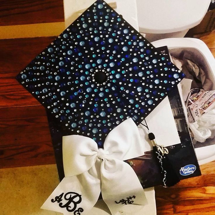 a black and white graduation cap with pearls on it sitting on top of a toilet