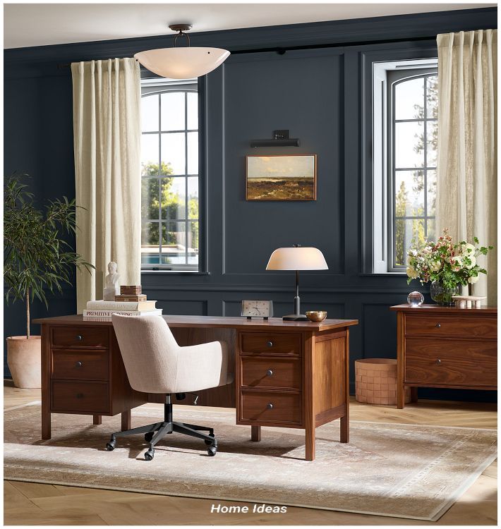 a home office with blue walls and wooden furniture in the corner, along with an area rug on the floor