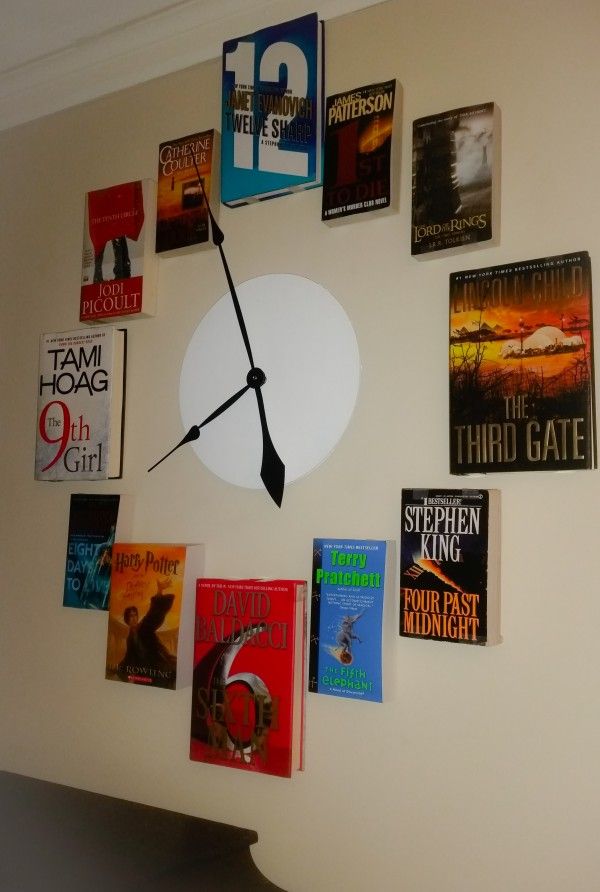 a clock made out of books on the wall