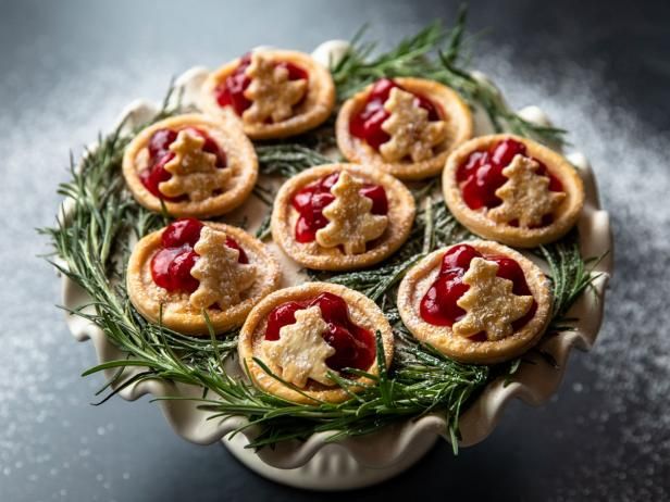 several small pastries are arranged on top of some green leaves and sprigs