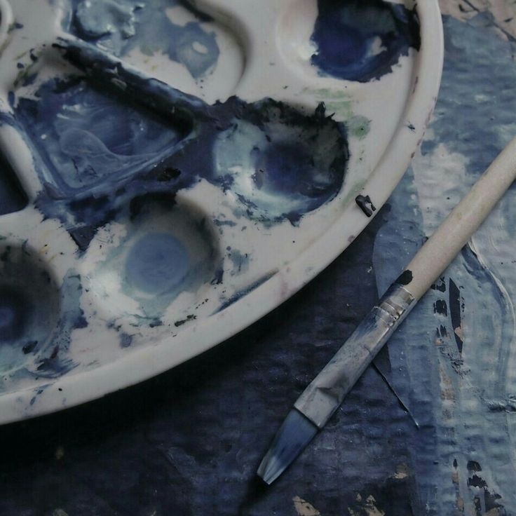 an artist's palette with paint and brushes on it