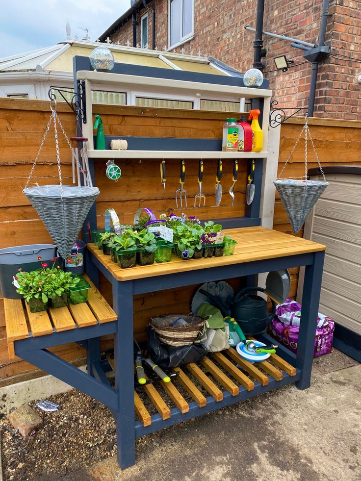 an outdoor potting bench with plants growing on it