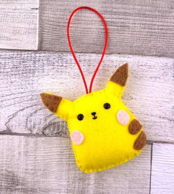 a yellow stuffed animal hanging from a red string on a white wooden background with wood planks