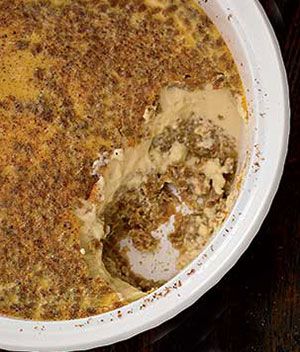 a white bowl filled with food on top of a wooden table