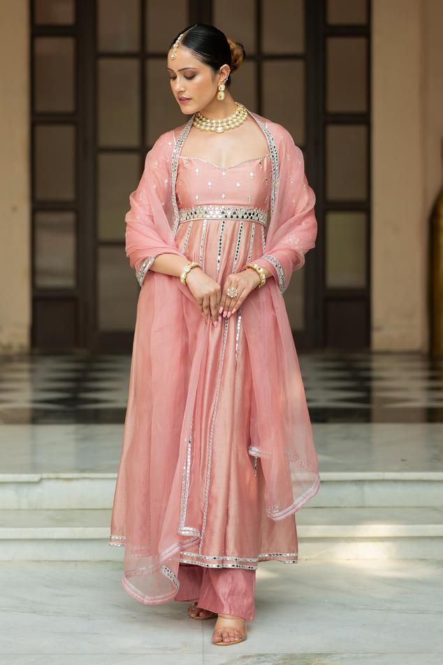 Onion pink padded anarkali with mirror embroidery. Comes with pant and a dupatta.
Components: 3
Pattern: Embroidered
Type Of Work: Mirror
Neckline: Sweetheart
Sleeve Type: Three quarter
Fabric: Semi crepe, Chanderi, Organza, Lining: Semi crepe
Color: Pink
Other Details: 
Attached lining
Product Weight: 1 Kg
Model Height: 5ft 9inches, wearing size S
Closure: Anarkali - Back tie-up
Occasion: Sangeet - Aza Fashions Pink Chanderi Salwar Kameez For Reception, Pink Chanderi Anarkali Set With Dabka Work, Pink Anarkali Kurta With Mirror Work, Pink Chanderi Choli, Pink Anarkali Set With Gota Work For Reception, Pink Anarkali Set With Dupatta, Pink Bollywood Style Dupatta, Pink Chanderi Salwar Kameez With Mirror Work, Pink Anarkali Set With Dabka Work