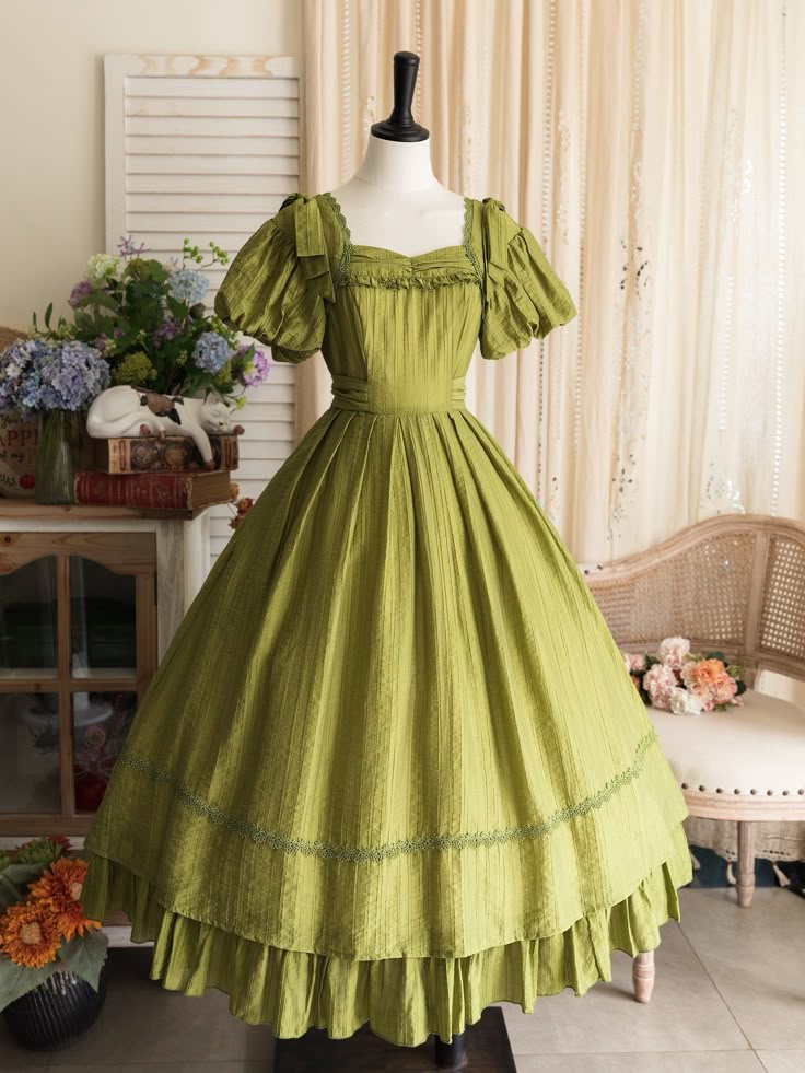 This price includes a dress and a green bowknot hairclip (not for sale).  Embrace timeless elegance with this enchanting Olive Green Puff Sleeves Classic Lolita Princess Tea-Length Dress. Designed for the true Lolita aficionado, this dress features delicately puffed sleeves and a flattering tea-length skirt that exudes sophistication and charm. The back boasts a comfortable shirring detail, ensuring a perfect fit for all body types. Whether you're attending a tea party, a cosplay event, or simpl Vintage Tea Party Dress, Green Tea Dress, Adventurecore Aesthetic, Forest Dweller, Country Lolita, Tencel Dress, Tea Length Skirt, Op Dress, Classic Skirts