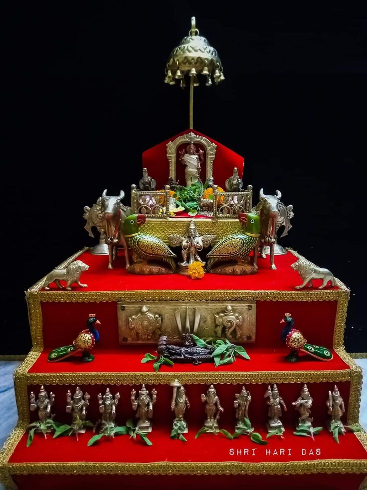 three tiered red and gold display with figurines on top