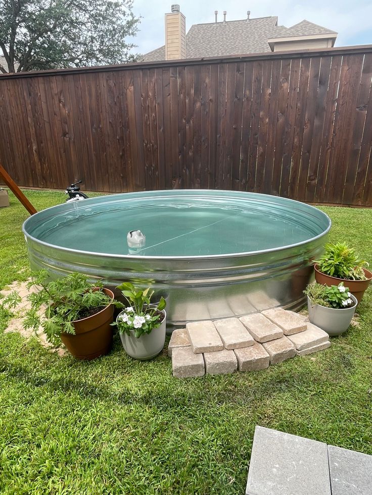 an outdoor hot tub surrounded by potted plants