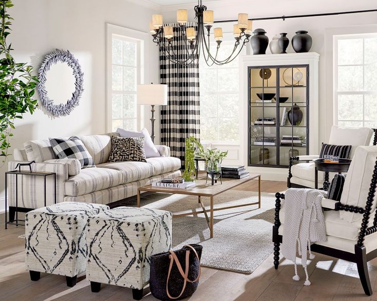 the living room is decorated in black and white checkered curtains, plaid furniture, and a chandelier