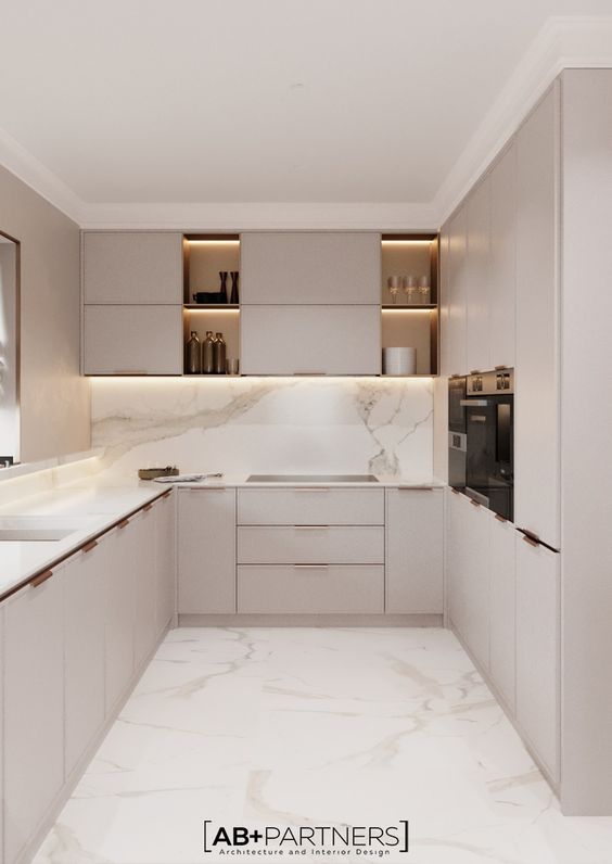 an empty kitchen with marble counter tops and white cupboards on the wall, along with stainless steel appliances