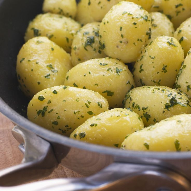 a pan filled with potatoes covered in parsley