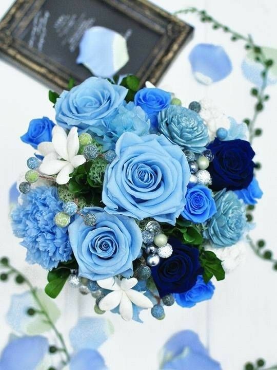 a bouquet of blue flowers sitting on top of a table