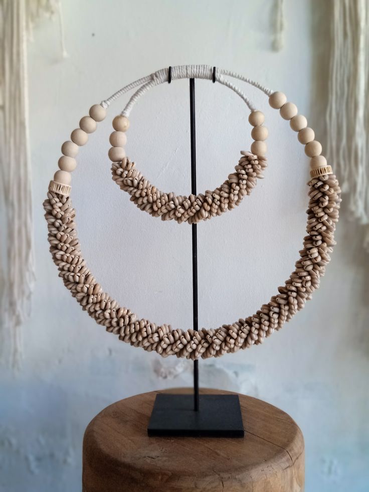 Handmade ceremonial Papua traditional Ornament from Indonesia. Made of white Shells . This Necklace is used in Papua for special rituals or ceremonies. Also is used as a payment between tribes. This beautiful piece is a very unique and powerful object in the Balinese culture. Size: L38, H38 high stand 47cm 0.8kg Perfect for elegant parties and all kind of Carnivals ! It can be wearied or used as a Decoration. You can buy with black metal stand You can buy without stand, you can hang it on the wa Traditional Natural Beaded Necklace Gift, Traditional Natural Beaded Necklaces As Gift, Traditional Natural Beaded Necklaces For Gifts, Traditional Beaded Necklaces As Gift, Artisan White Necklaces For Festivals, White Artisan Jewelry For Festivals, Handmade White Jewelry For Traditional Ceremonies, Artisan White Jewelry For Festivals, Traditional Cream Necklace As A Gift