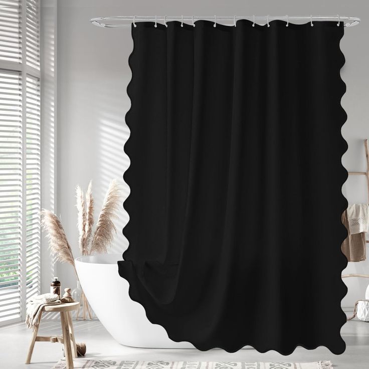 a black shower curtain with white scalloped edges in a modern bathroom, next to a bathtub