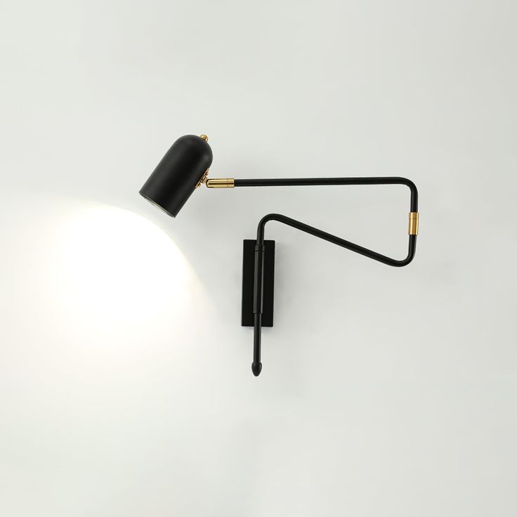 a black wall lamp with a white light on it's side and an arm that is attached to the wall