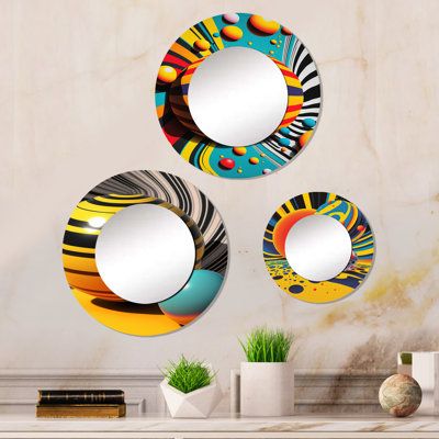 three circular mirrors are hanging on the wall next to a vase and potted plant