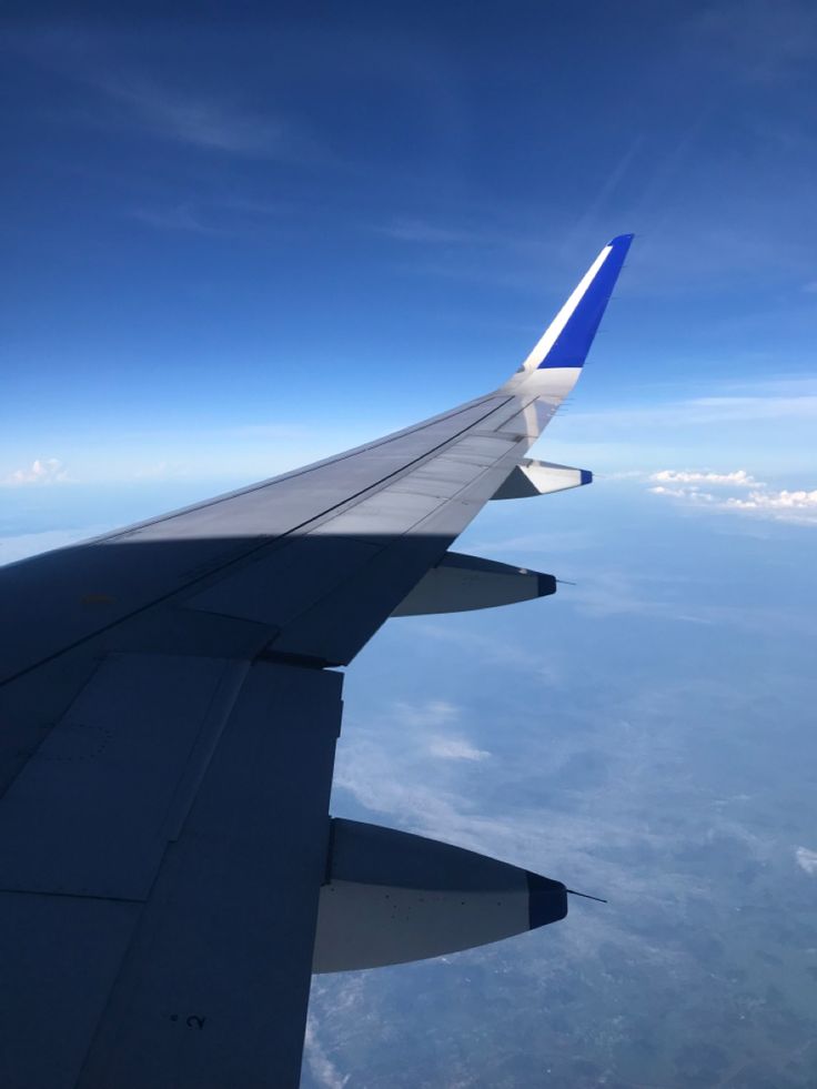 the wing of an airplane flying in the sky