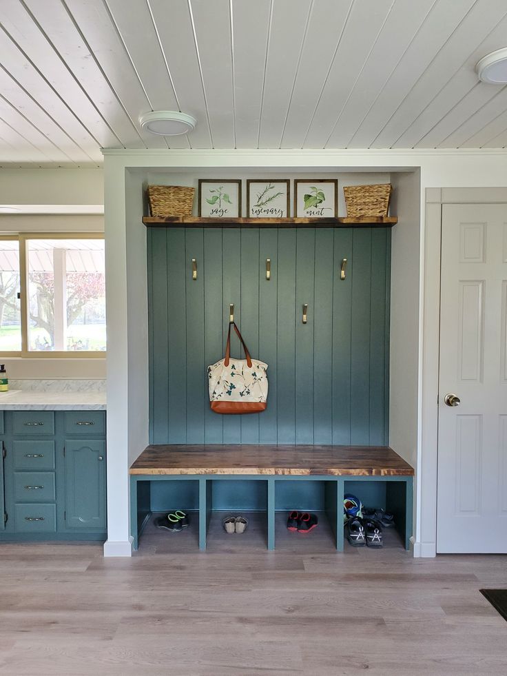 a blue bench in the middle of a room with two baskets on it's back