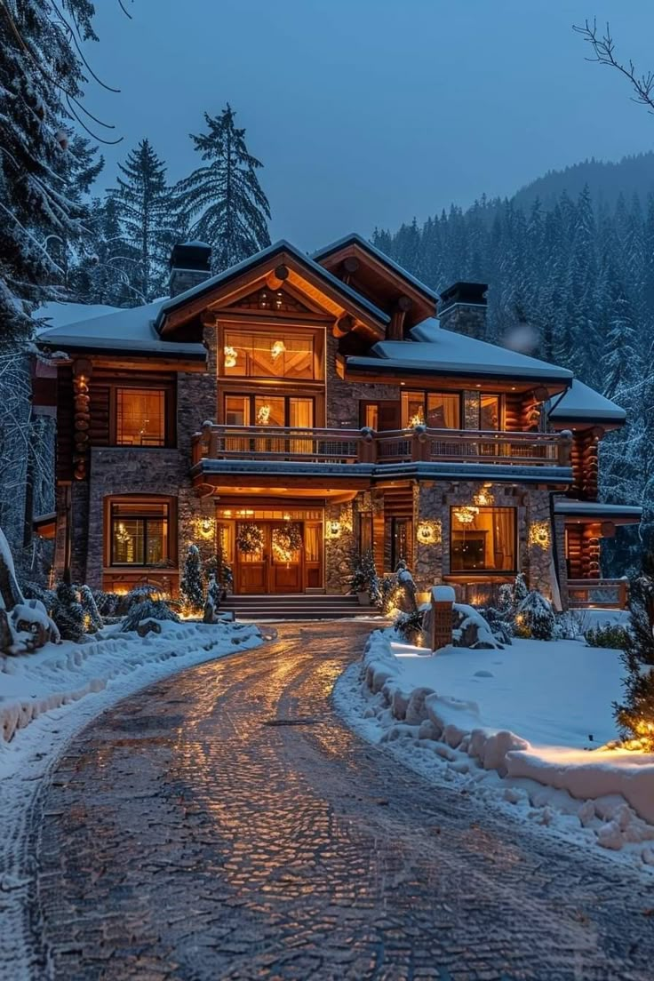 a large house is lit up at night in the snow