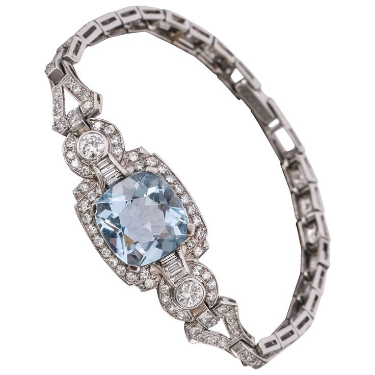 c.1920's Art Deco Aquamarine gemstone, diamond, and platinum link bracelet. The center section of bracelet (former watch case), measures approximately 18 mm length x 15 mm width, holds a large cushion shape Aquamarine gemstone that measures approximately 11.5 mm length x 11 mm width x 7.3 mm height. The gemstone is light blue in color and clean. Center Aquamarine stone is bordered by 24 single cuts, 6 baguettes, and 2 round diamonds for an estimated weight of approximately .57 carat total. Cente Luxury Jewelry Store, Royal Jewellery, Bijoux Art Deco, Jewellery Bracelets, Art Deco Bracelet, Jewelry Appraisal, Platinum Jewelry, Aquamarine Jewelry, Jewelry Rings Diamond