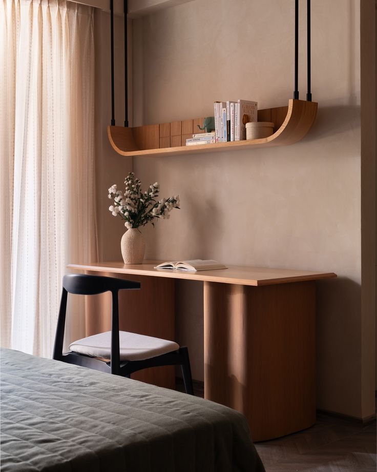 a room with a bed, desk and shelves on the wall next to a window