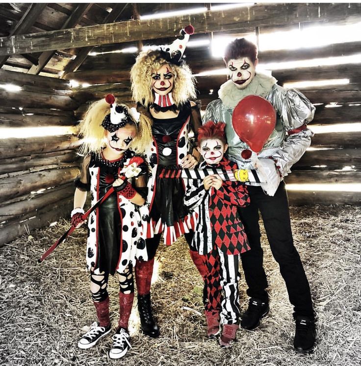 three people dressed up as clowns posing for a photo