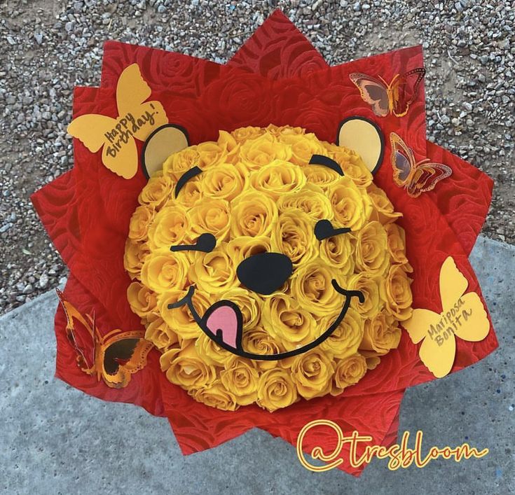 a lion made out of yellow roses with butterflies on it's head and eyes