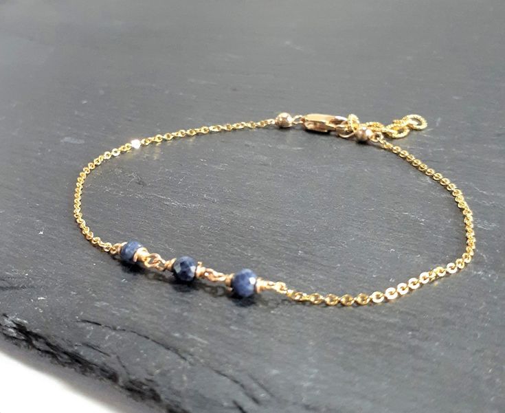 This beautiful handmade anklet features 3 Genuine Blue Sapphire gemstones wrapped in the metal of your choice. Dainty, minimal, and elegant, this bracelet is the perfect finishing touch to any style or event. Makes a great gift to add to any gemstone lover's collection. Perfect to gift for Christmas, Valentine's Day, Mother's Day, and more! Gemstone: Sapphire Gemstone Size: 3.0 mm Gemstone Shape: Rondelle, Faceted Metal: 14k Gold Filled or Sterling Silver (Nickel Free) Anklet Length: 9 inches (m Elegant Blue Anklets For Gifts, Elegant Blue Anklets For Gift, Elegant Adjustable Anklets For Everyday Wear, Elegant Blue Bracelets With Delicate Chain, Minimalist Blue Bracelet With Delicate Chain, Elegant Blue Bracelet With Delicate Chain, Handmade Sapphire Minimalist Jewelry, Handmade Minimalist Sapphire Jewelry, Adjustable Sapphire Jewelry With Natural Stones