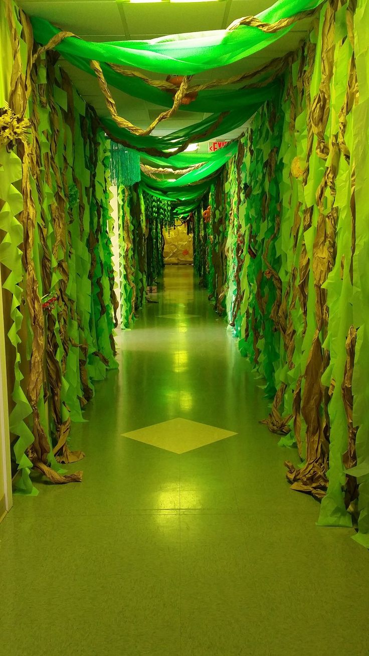 the hallway is decorated in green and gold colors with trees on both sides, along with drapes covering the floor