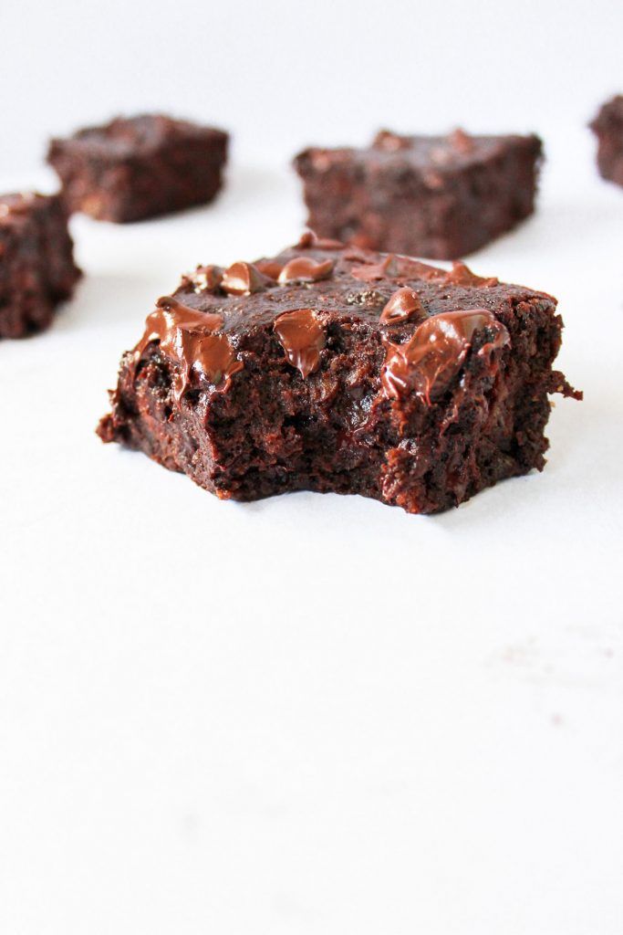 several pieces of chocolate brownie on a white surface