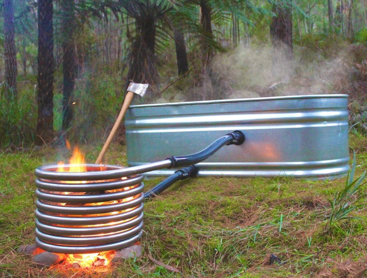 a large metal container sitting on top of a grass covered field next to a fire