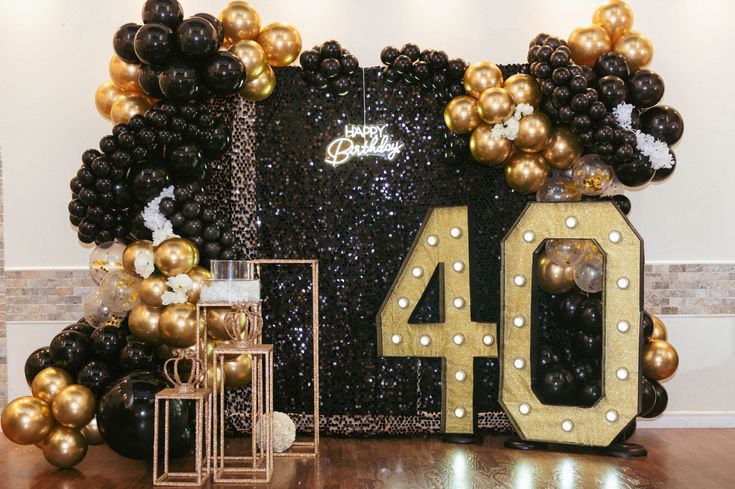 black and gold balloons with the number forty displayed in front of an entrance to a party