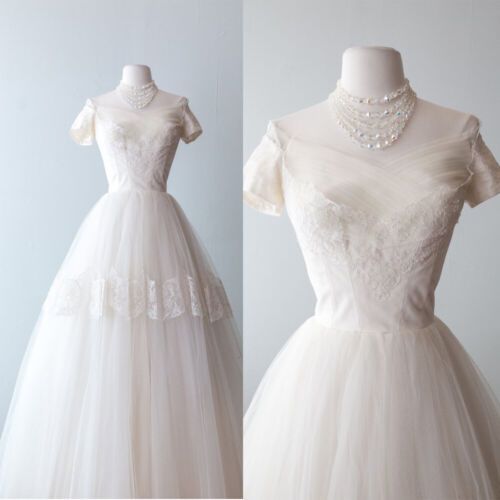 the dress is made up of white tulle and has an off - shoulder neckline