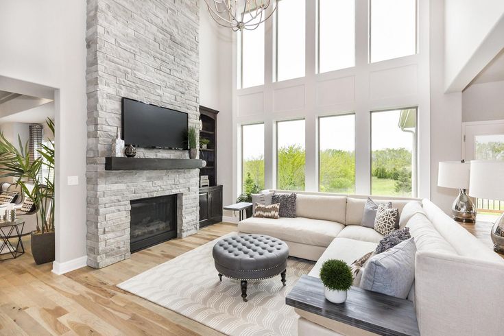 a living room filled with furniture and a flat screen tv mounted to a wall above a fireplace