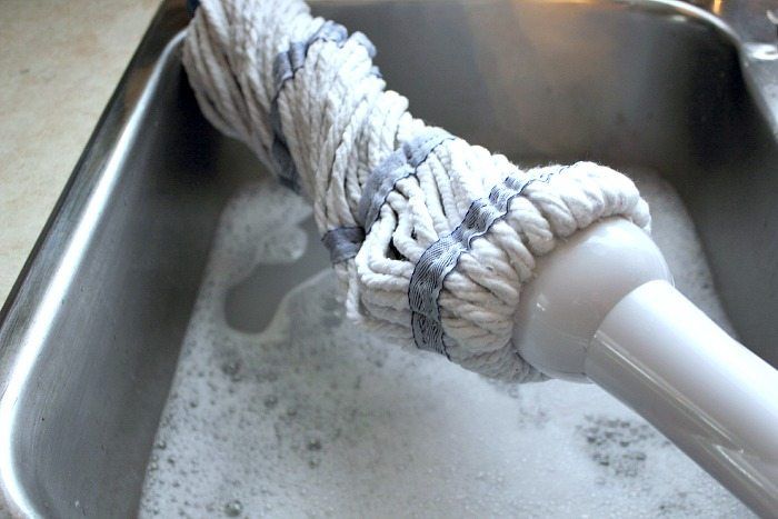 a large metal sink filled with water and a white rag wrapped around the handle on it