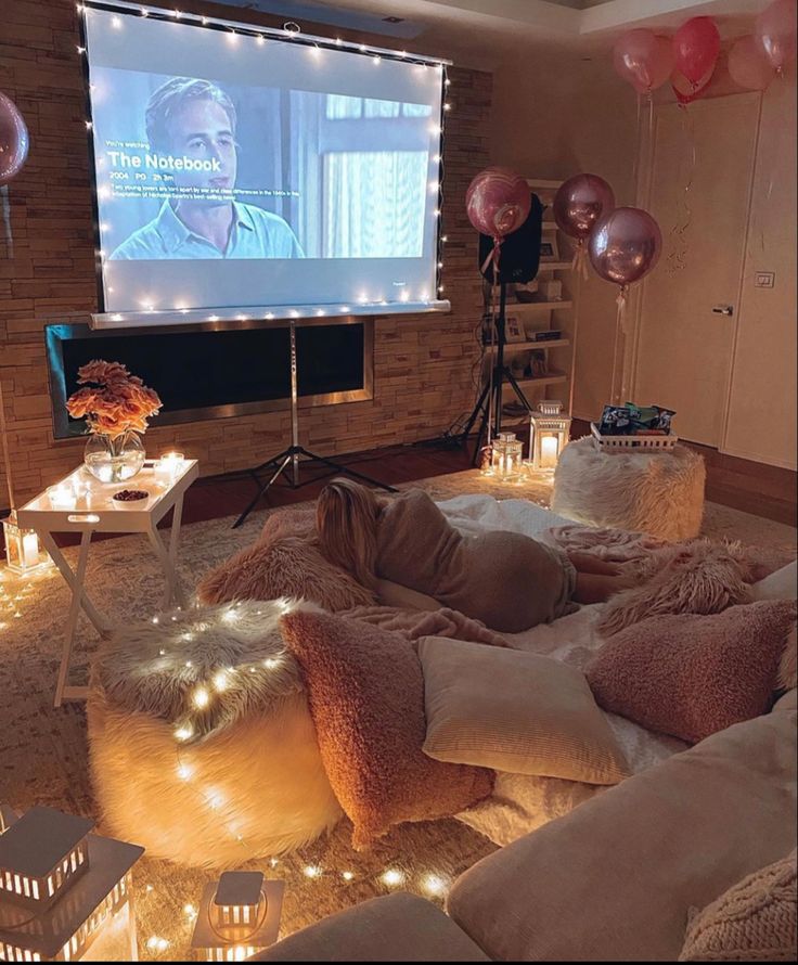 a living room filled with lots of furniture and balloons in the air, while someone is watching tv