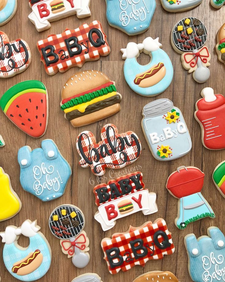 many decorated cookies on a wooden table with the words bbq and baby written in them