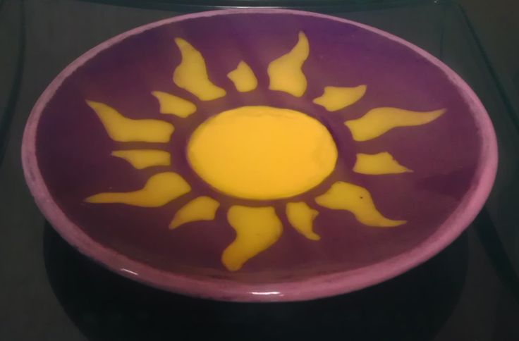 a purple and yellow bowl sitting on top of a table